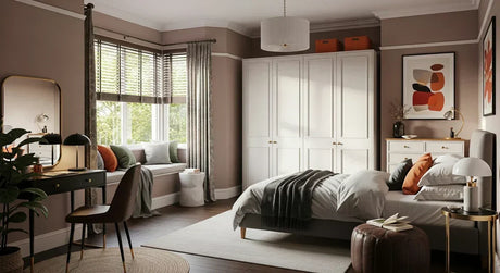 White wardrobe in an eclectic bedroom placed in large wall recess with sunlight entering room through window blinds