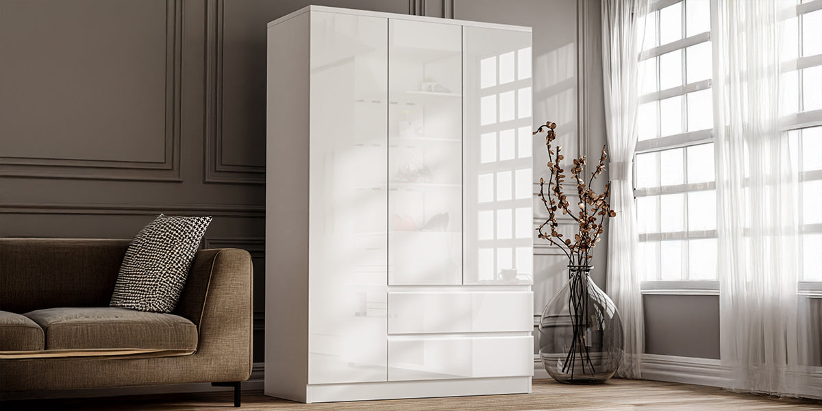 Modern white gloss triple door wardrobe with drawers featuring a sleek, handleless, modular design in a bedroom