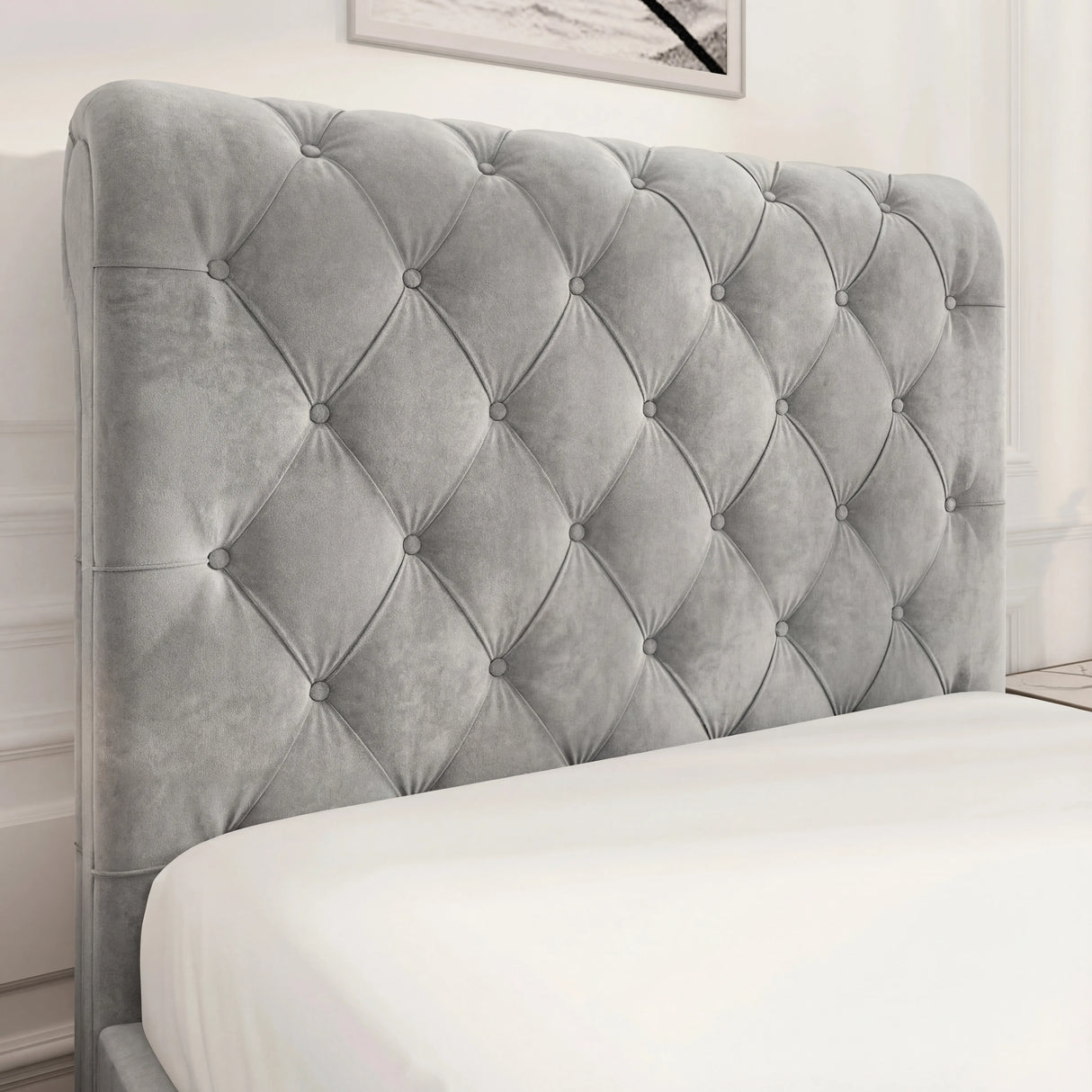 Detailed view of light grey tufted headboard with Chesterfield design, featuring soft velvet fabric and deep button accents.