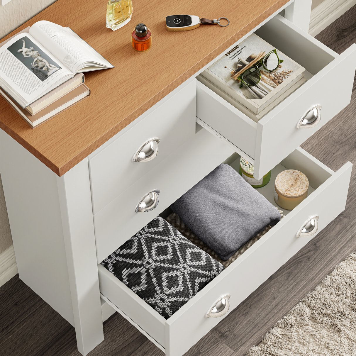 Open drawer view of white shaker chest showing neatly folded clothes and accessories, highlighting drawer depth and use.