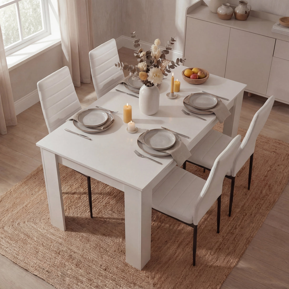 Top view of compact white dining table set for 4 with white PU leather chairs, styled for cozy and modern dining areas.