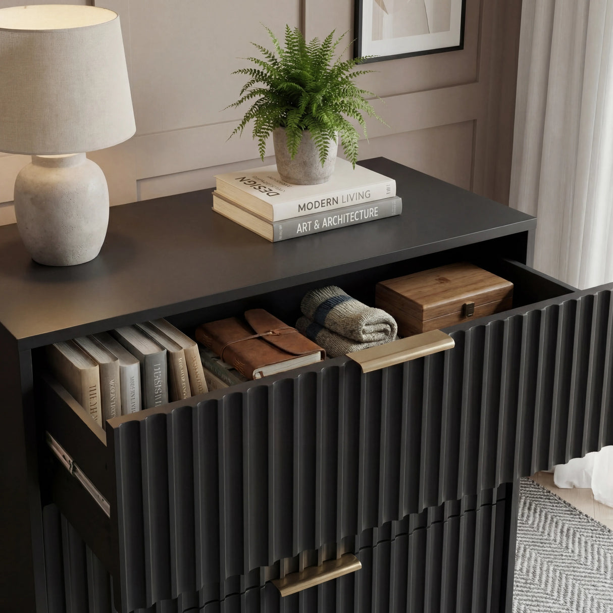 Black five drawer cabinet top surface styled with decor to show depth and flat profile in a modern room with natural lighting