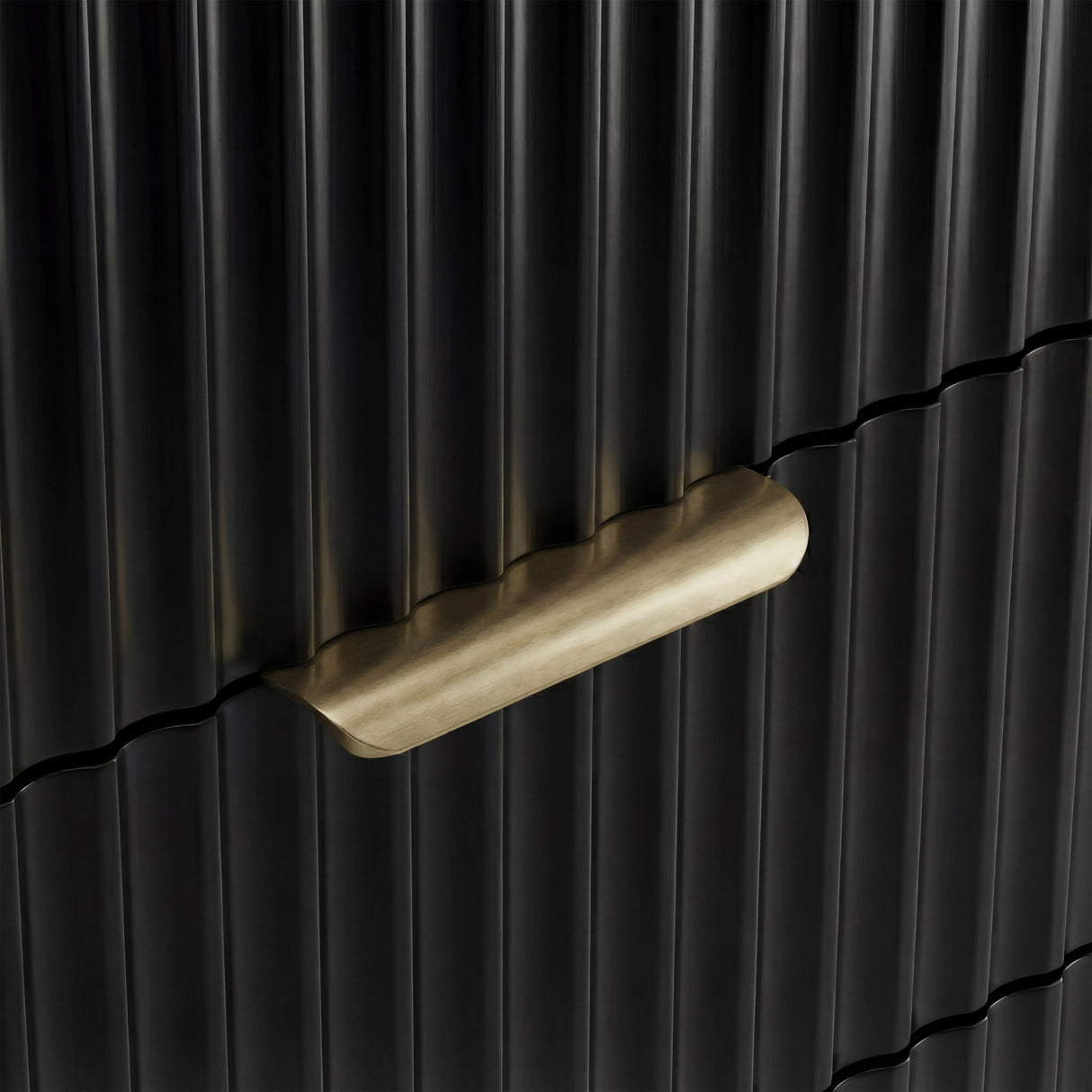 Gold metal handle detail on a black flutrina chest of drawers front with vertical sturdy panel design