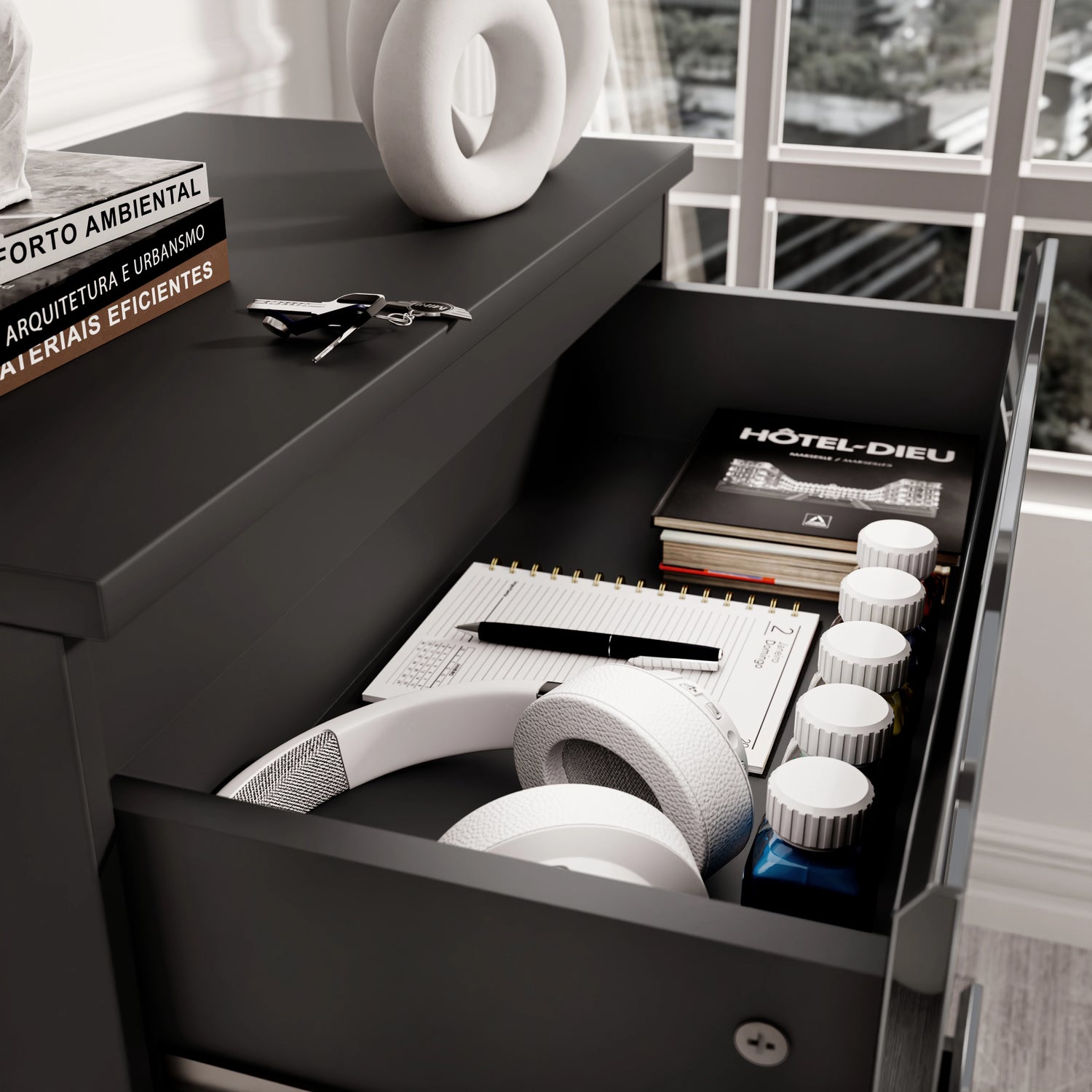 Close-up of drawer in black high gloss chest, showing storage for headphones, notebooks, and daily essentials.