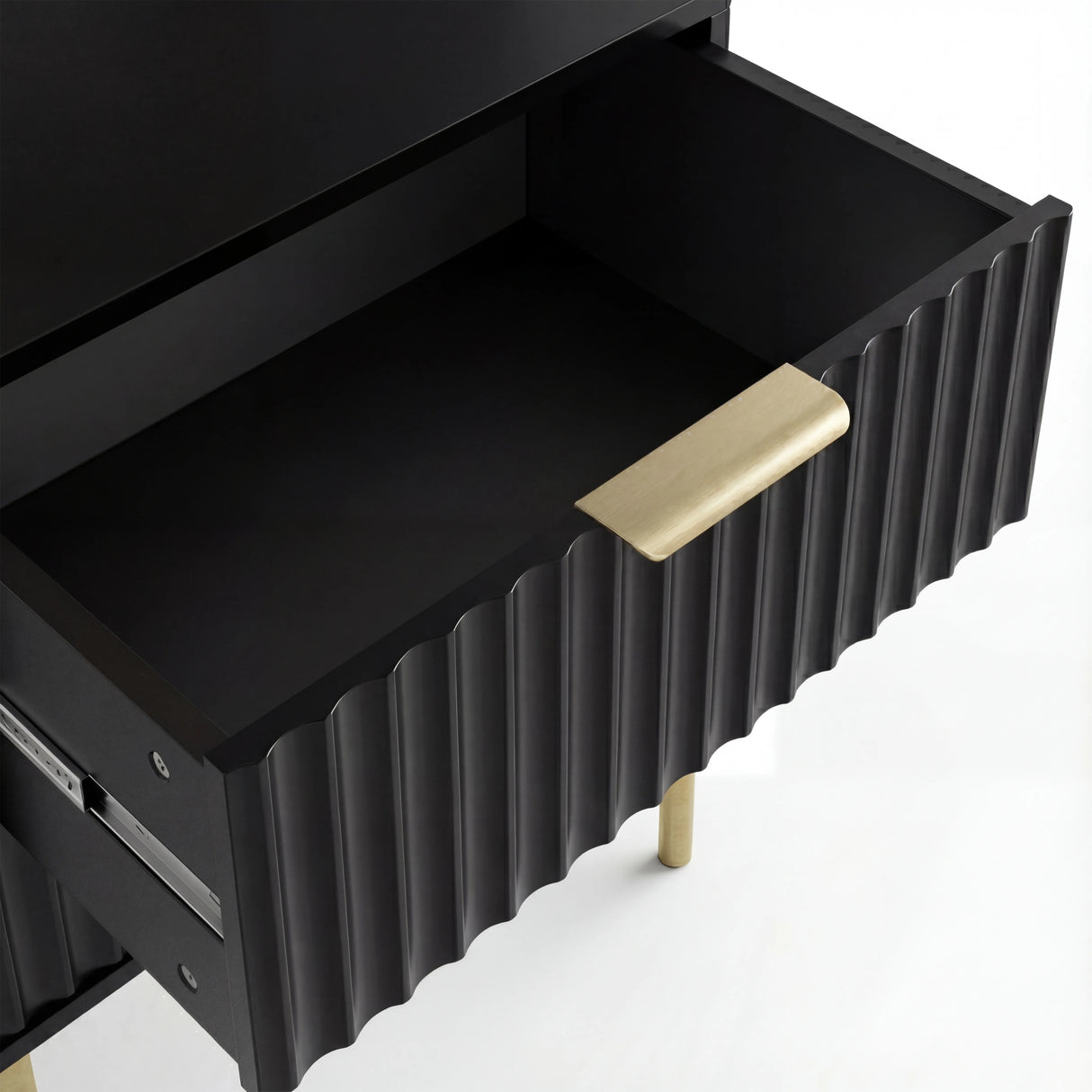 Interior compartment of black painted drawer showing smooth storage finish with golden sleek metal handles