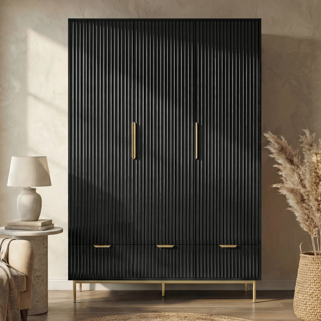 Front view of black 3 door wardrobe with lower drawer section and brushed golden finish metal handles