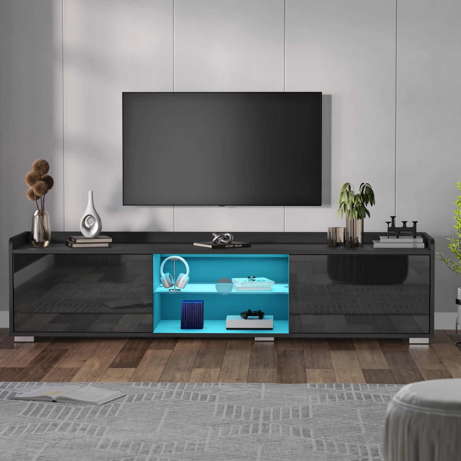 Modern black TV stand with a blue illuminated shelf in a living room setting.