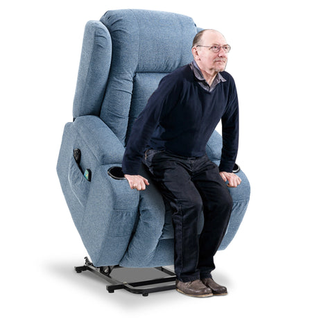 Blue fabric stand up recliner chair fully elevated, ready to assist a person to stand.