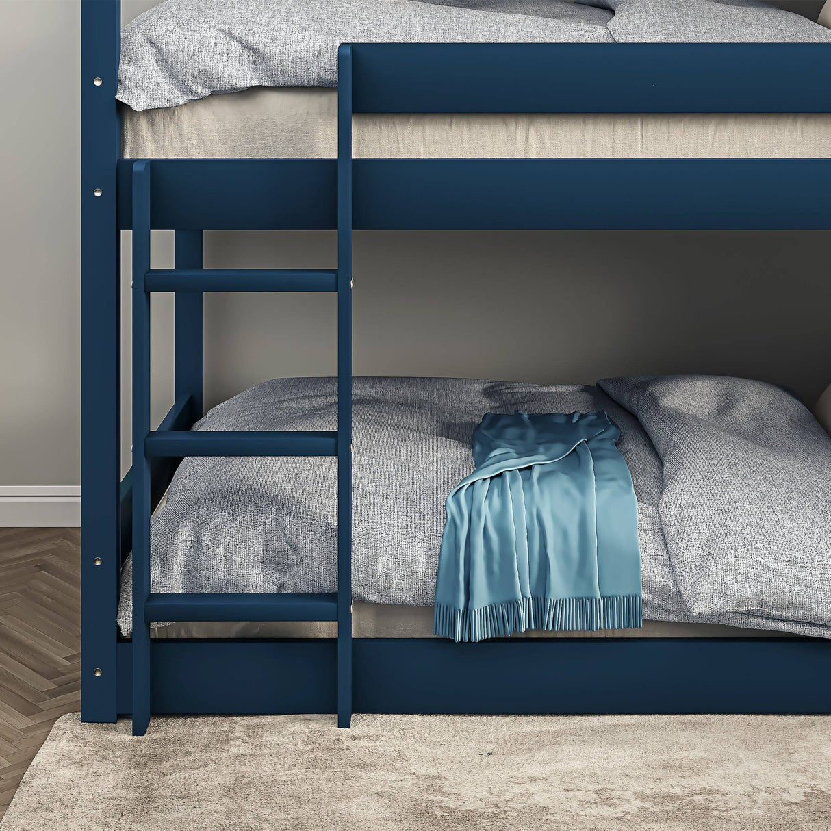 Close-up of lower section of navy blue triple bunk bed. Features include a secure ladder and cozy bedding, perfect for children's rooms.