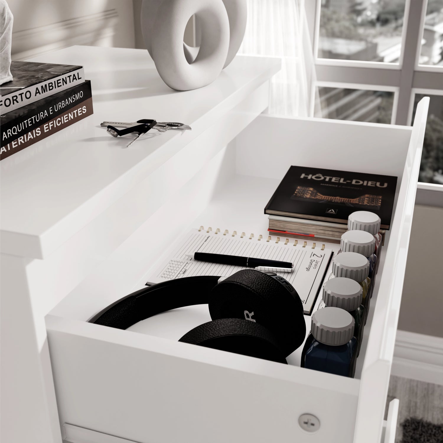 Top drawer of white High Gloss Chester Drawers with headphones, notebooks, and paint bottles, highlighting versatile storage use.