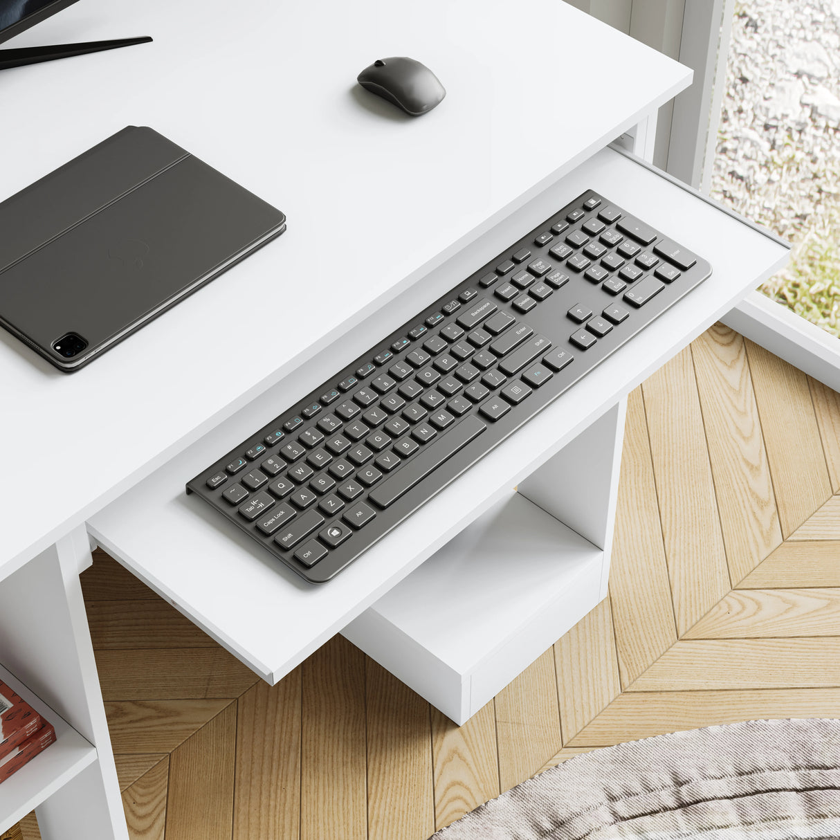 Black keyboard on a white desk with a tablet and mouse