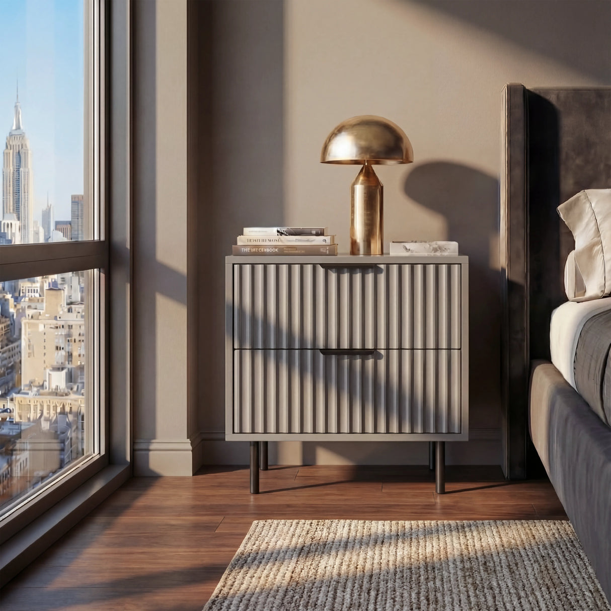 Grey bedside cabinet with drawer storage containing black handles and legs positioned beside a bed in a room