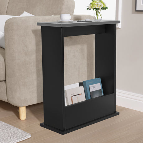 Black side table with books and a vase in a living room setting