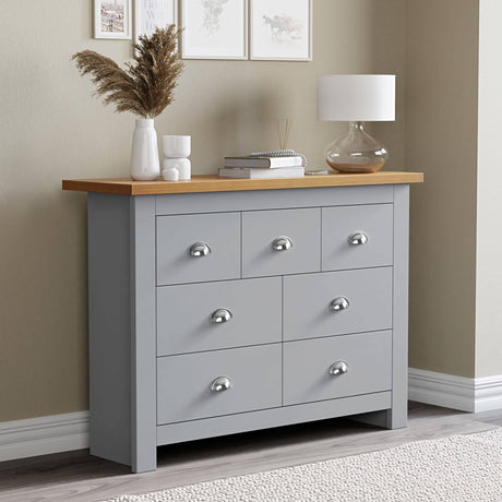 Grey chest of drawers with oak top surface, perfect for flower pot display and additional storage.