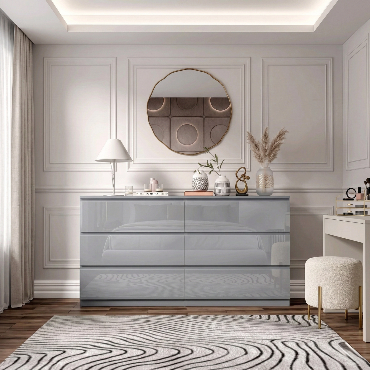 Grey high gloss six chest of drawers placed against a wall in a modern room with a large round mirror and decorative items