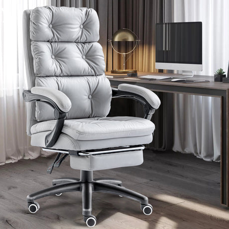 The grey office chair is featured in a minimalist home office with a PC setup in the background.