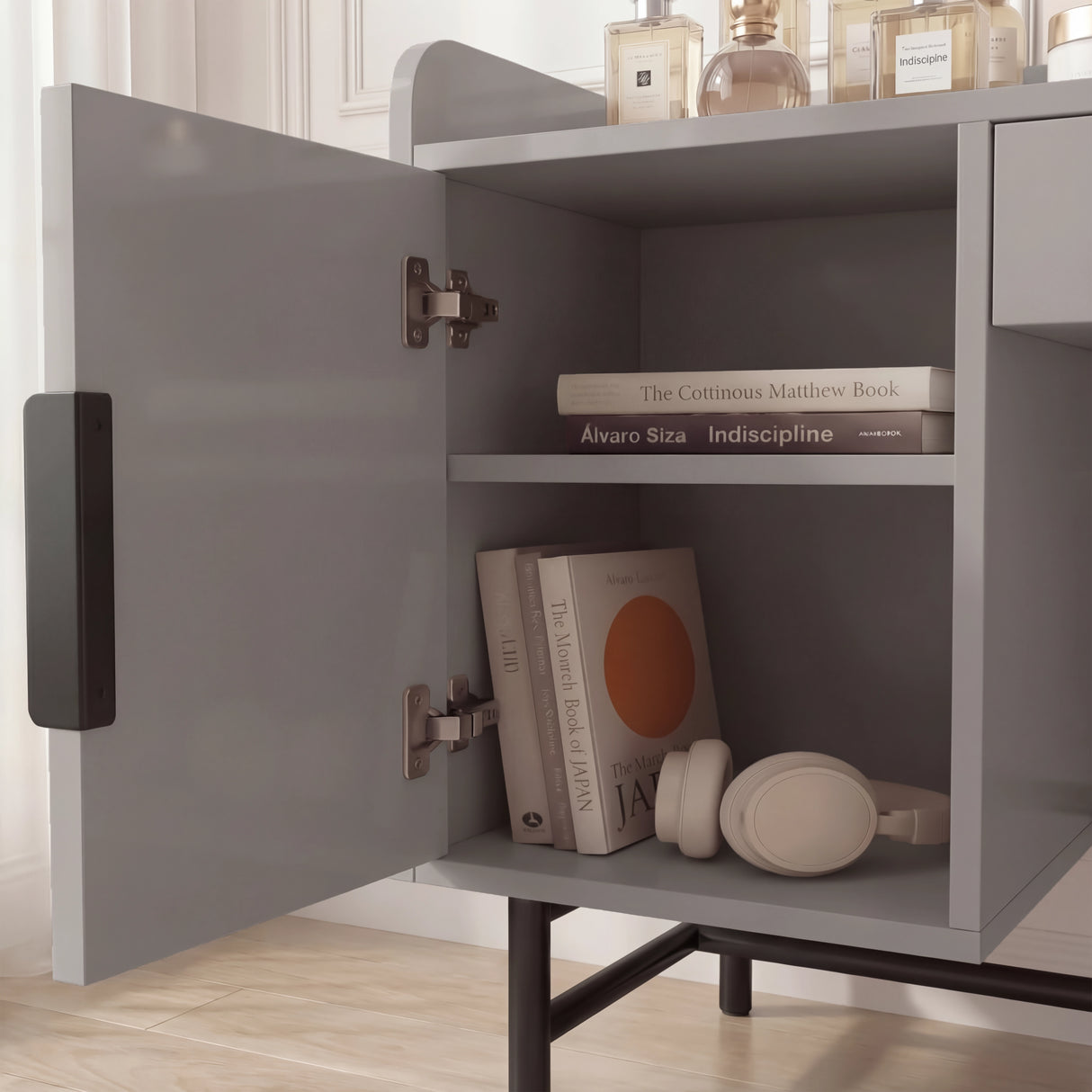 Close-up view of the grey dressing table with open shelves, displaying storage items like books and other items