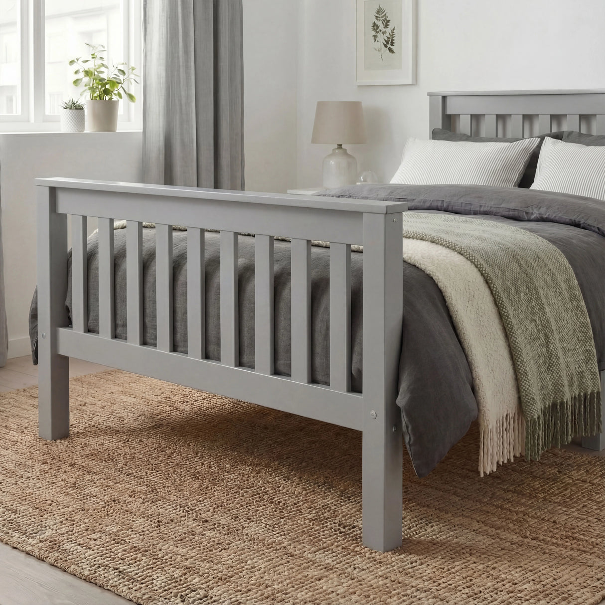 Grey single bed frame with slatted pattern and footboard, neutral bedding, and a minimalist bedroom decor