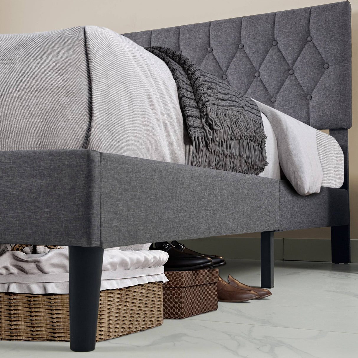 Under-bed storage space of the Linen Grey Bed Frame, showing clearance for baskets and shoes on a tiled floor.