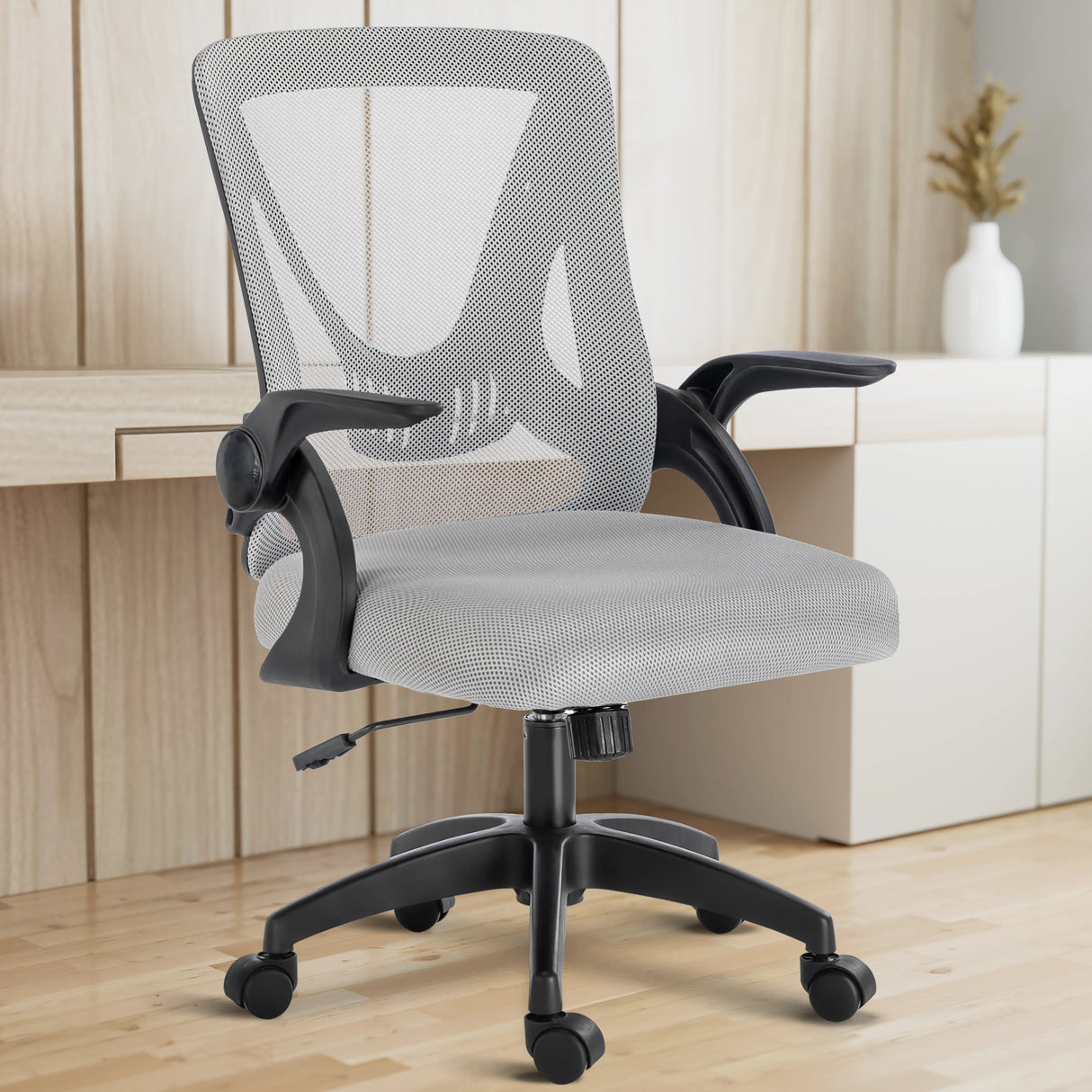 With a working desk in the background, the grey mesh chair fits seamlessly into a modern home office setup.