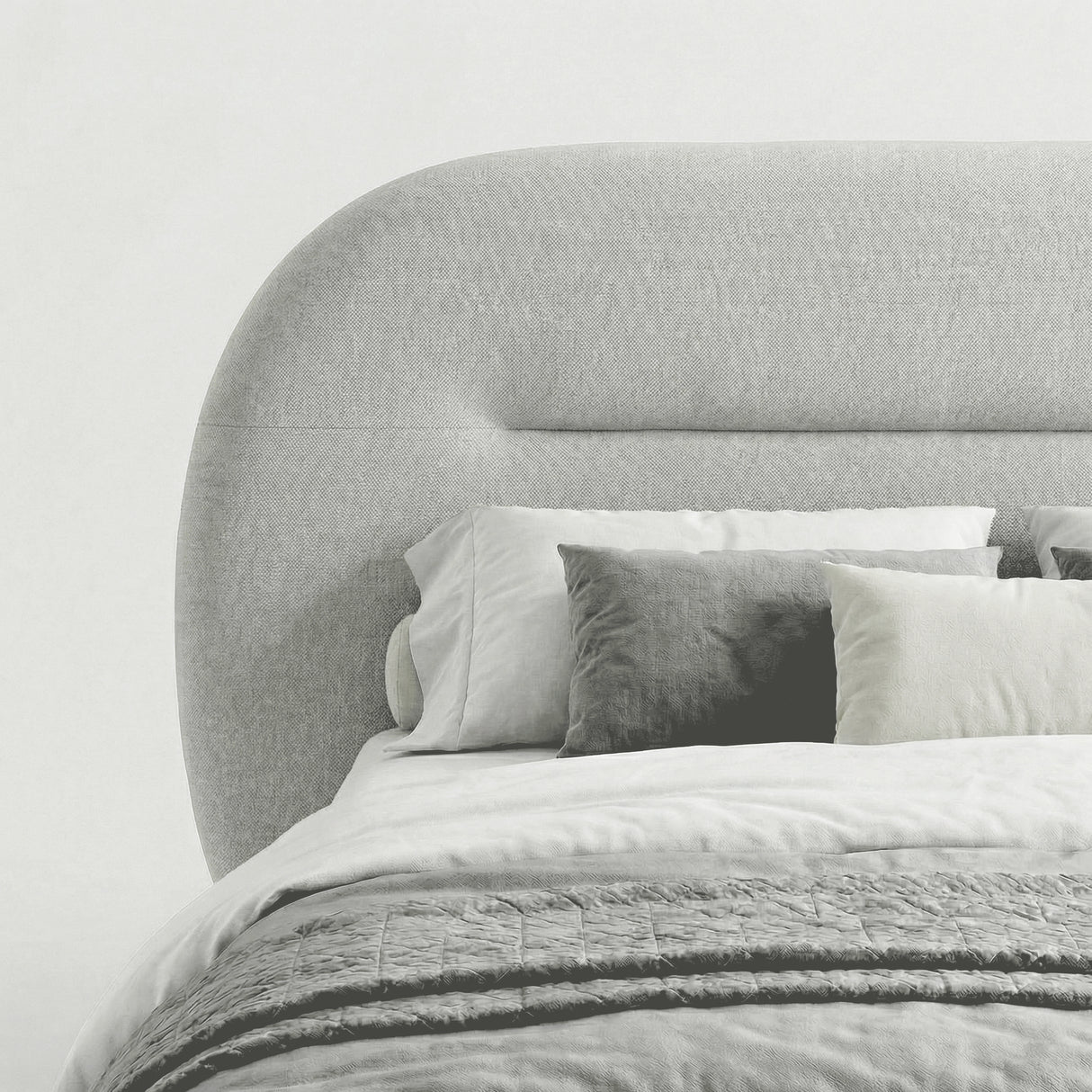 Close-up view of the padded headboard on the grey upholstered bed frame with light bedding