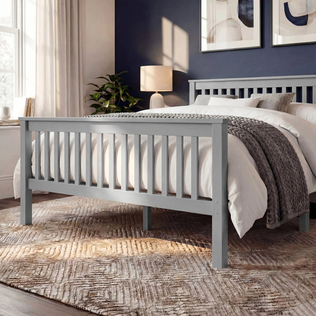 Grey wooden bed frame with vertical slat detailing on both the headboard and footboard, placed in a bedroom