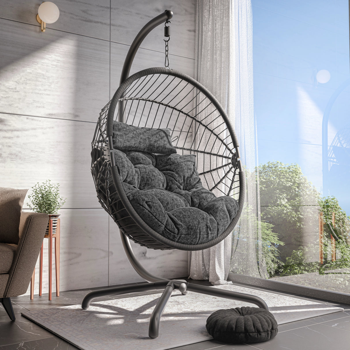 Black hanging chair with cushion in a modern room with large window