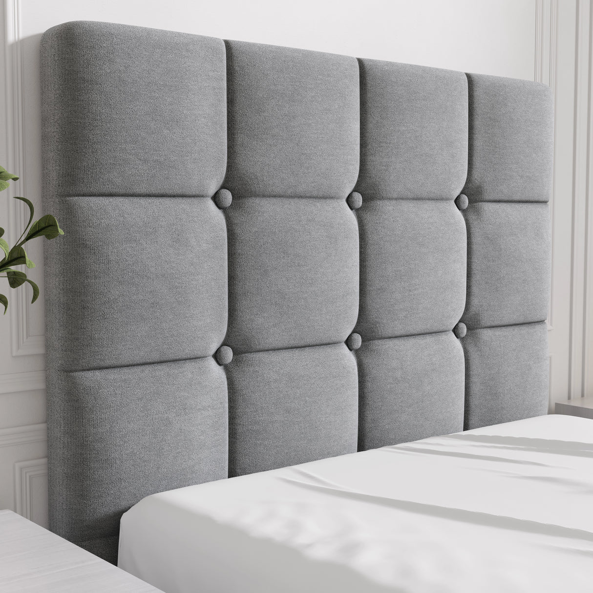 Gray tufted headboard on a bed with white bedding
