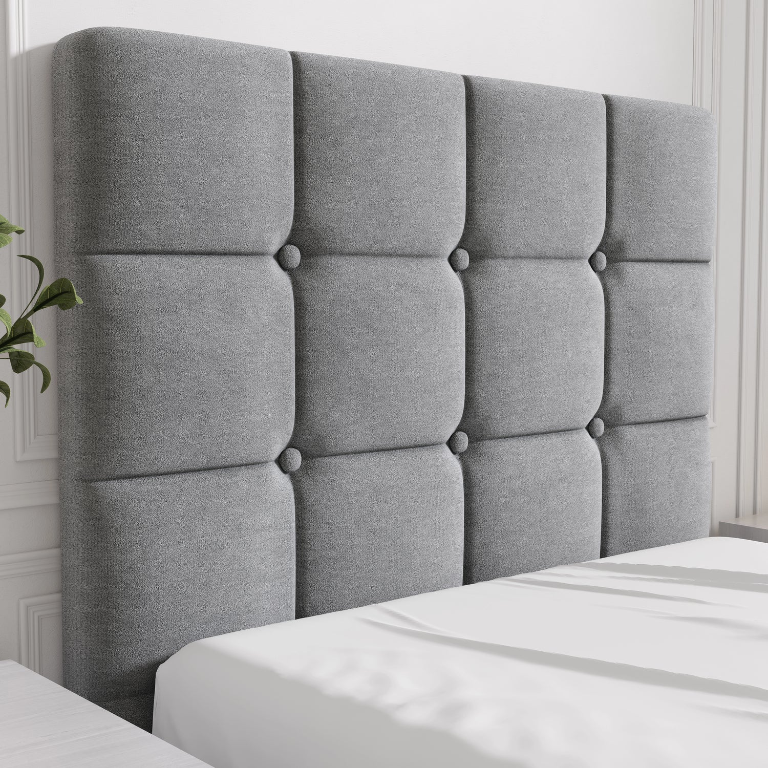 Gray tufted headboard on a bed with white bedding