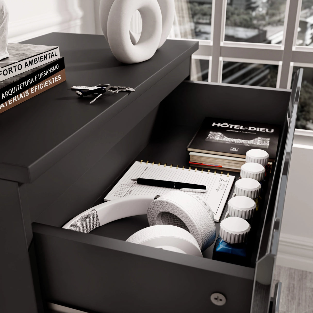 Top drawer of black High Gloss Chester Drawers showing storage of books, headphones, and accessories for multipurpose use.