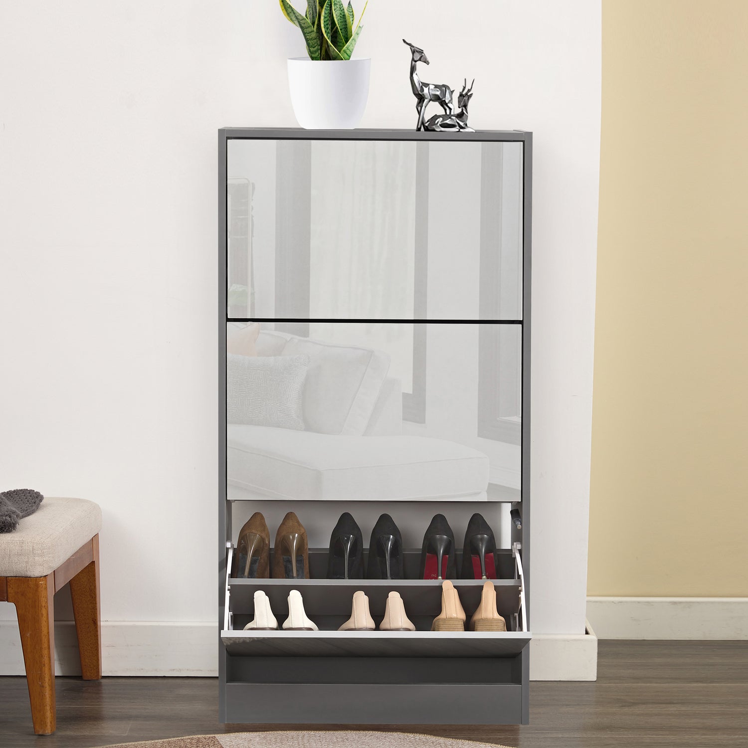 Front view of wooden shoe cabinet with bottom drawer open, showing multiple shoes stored inside.