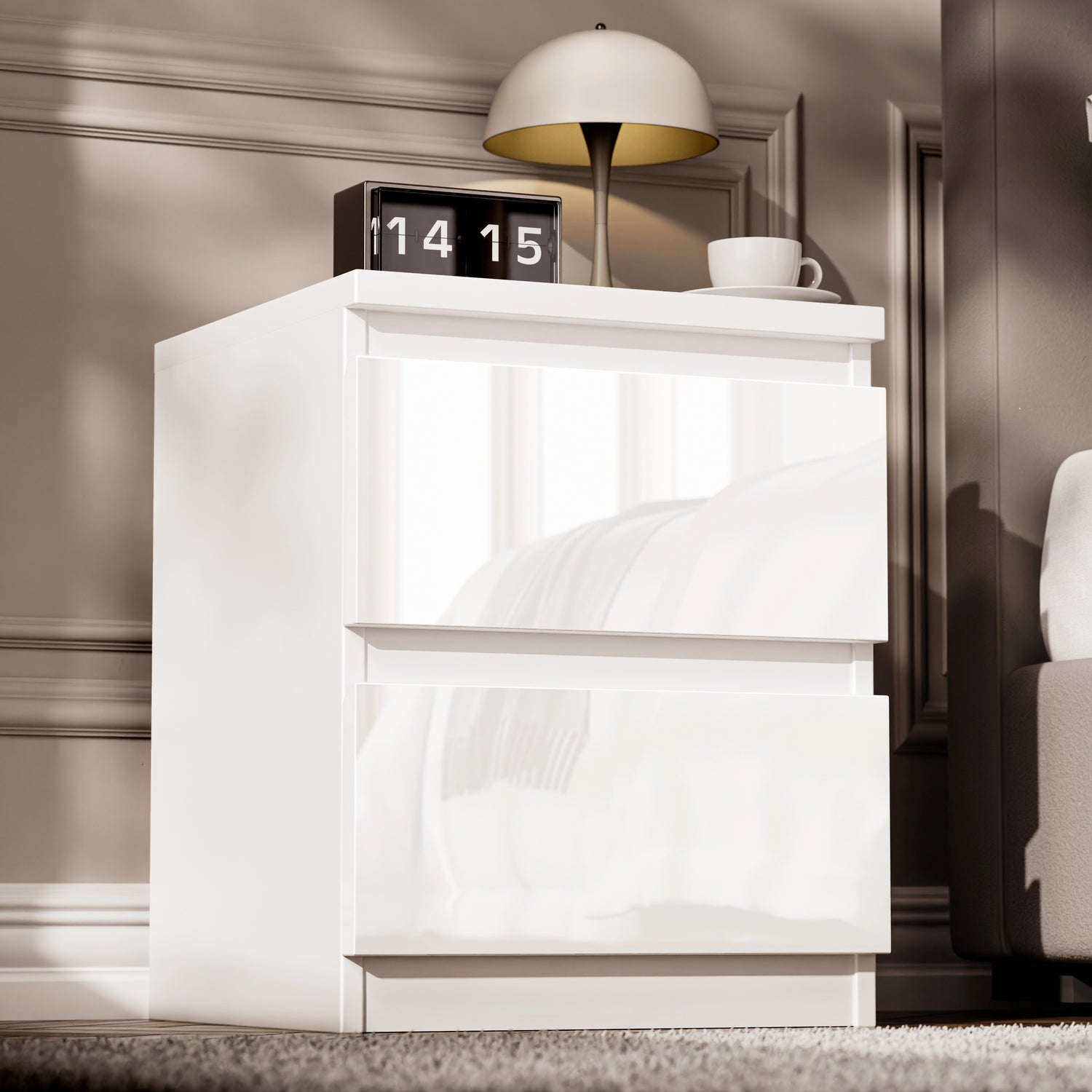High Gloss 2 Drawer Bedside Table in white with modern design, placed beside a bed with a lamp, clock, and cup on top. Ideal for bedroom storage.