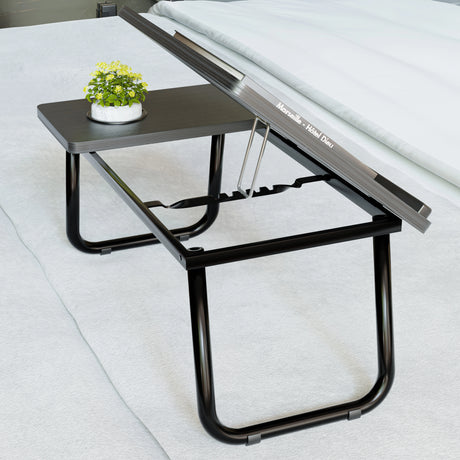 Portable folding laptop desk with height adjustable top and built-in cup holder, ideal for bed or floor use. Sleek black design with sturdy legs.