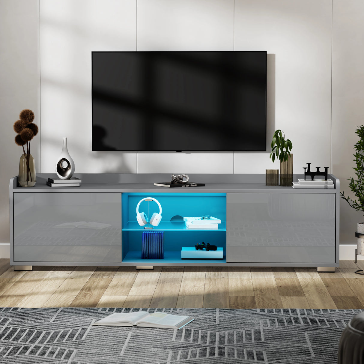 Modern TV stand with a television mounted on a wall, featuring decorative items and a blue lighted shelf.