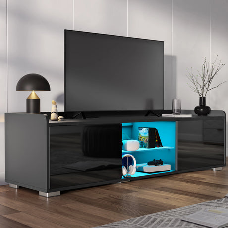 Modern black TV stand with a television and decorative items in a room.