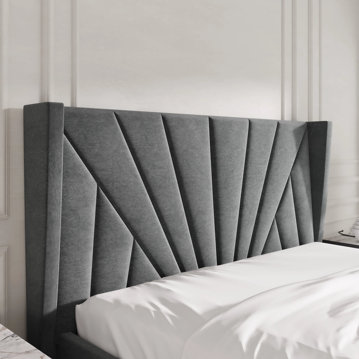 Gray upholstered headboard on a bed with white bedding against a neutral wall.