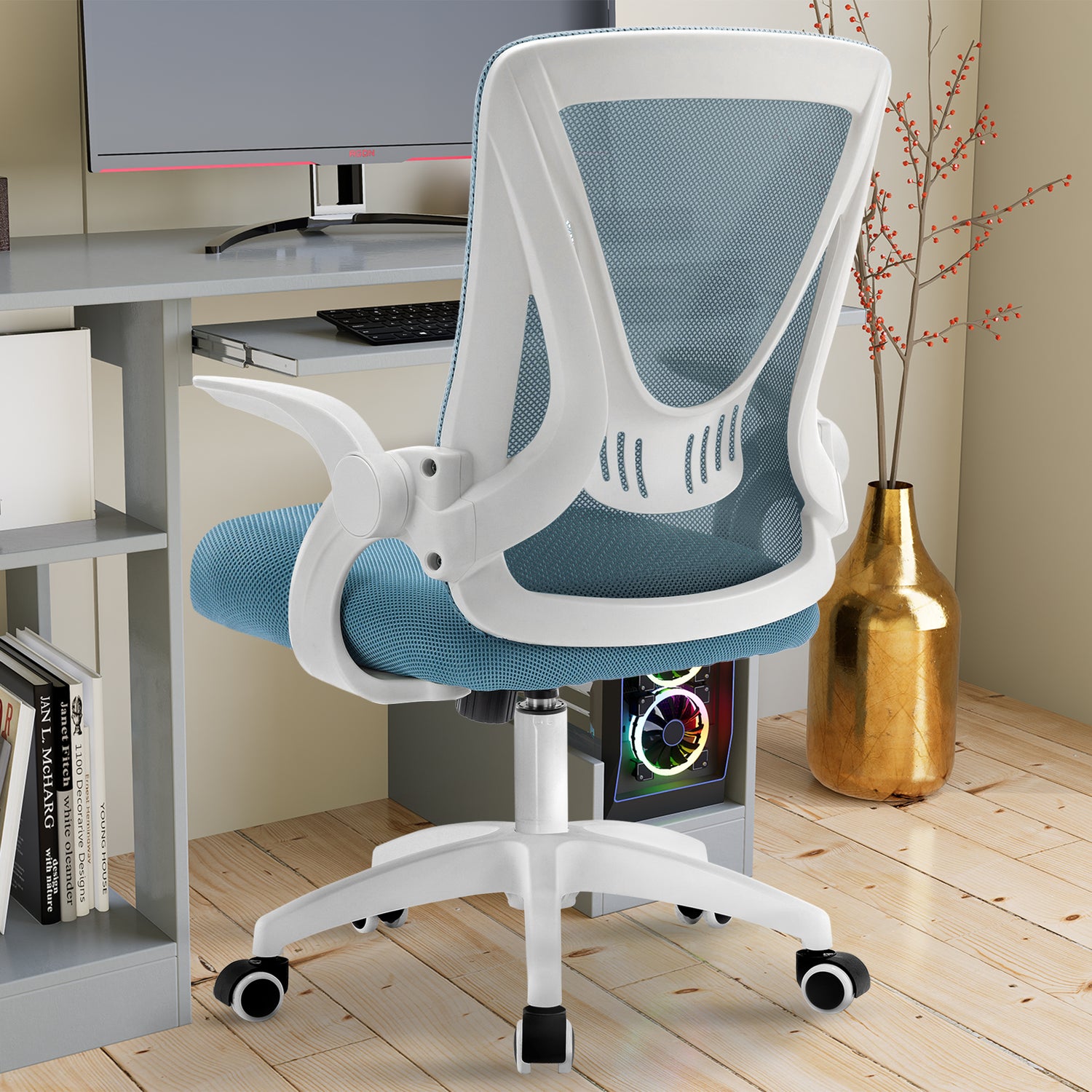 Adjustable chair with mesh backrest and flip-up armrests, placed near a PC workstation for ultimate comfort.