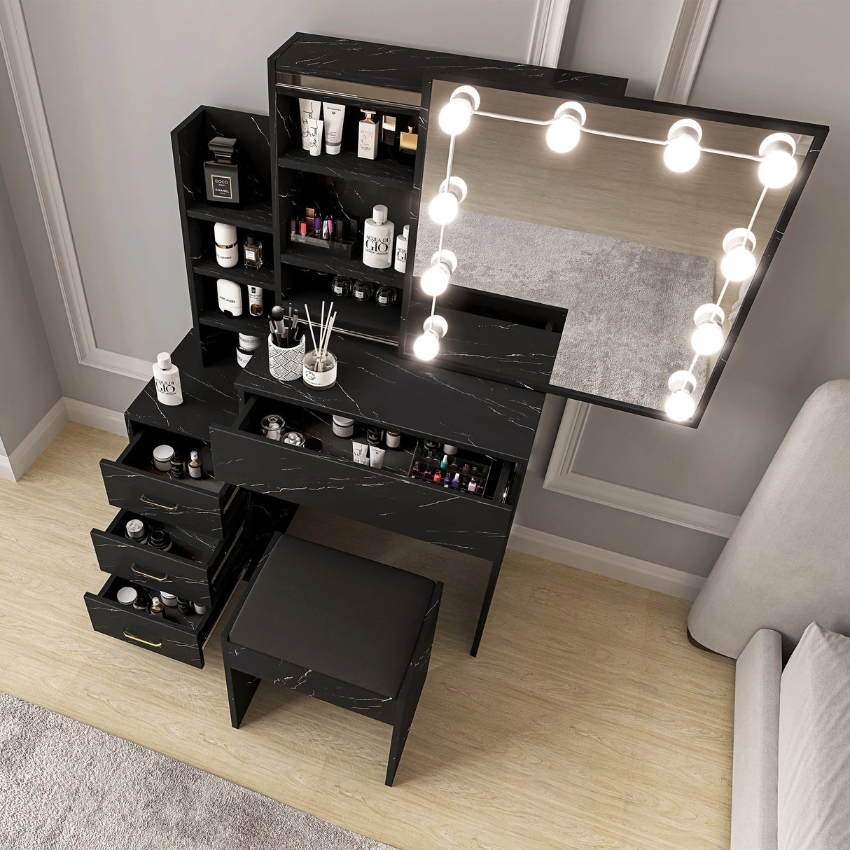 Black marble makeup vanity with mirror and lights in a room setting.
