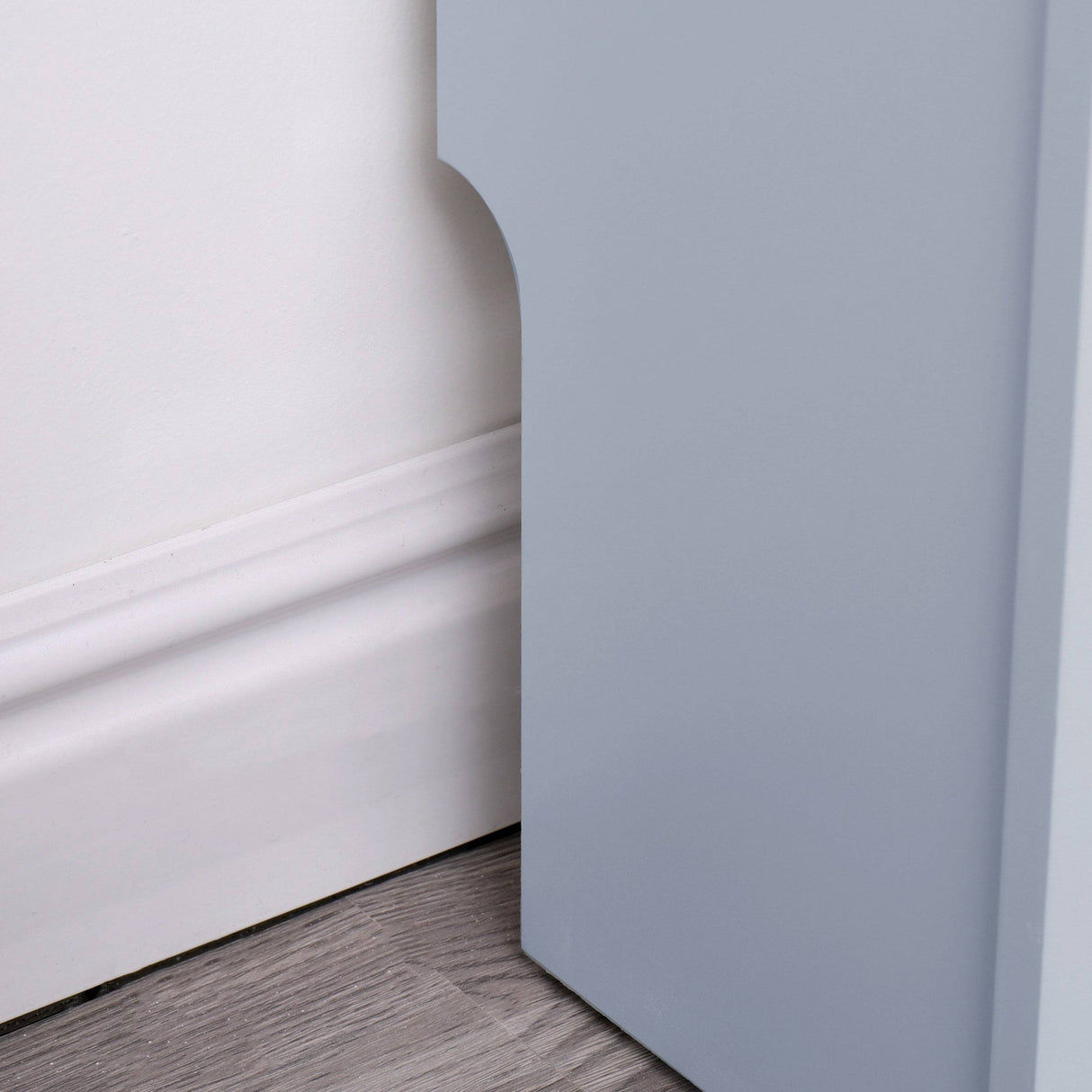 bottom edge of adjustable radiator covers in grey showing skirting board notch fitting flush to the wall