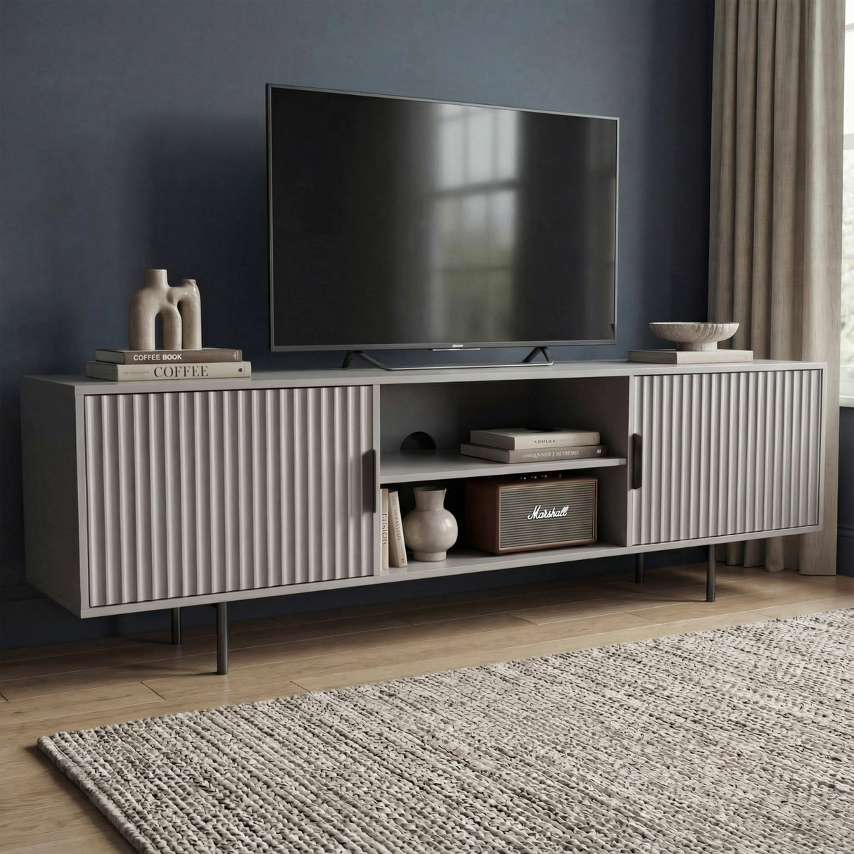 Modern grey TV unit with vertical fluted doors and open shelving, providing a sleek storage solution for contemporary homes.