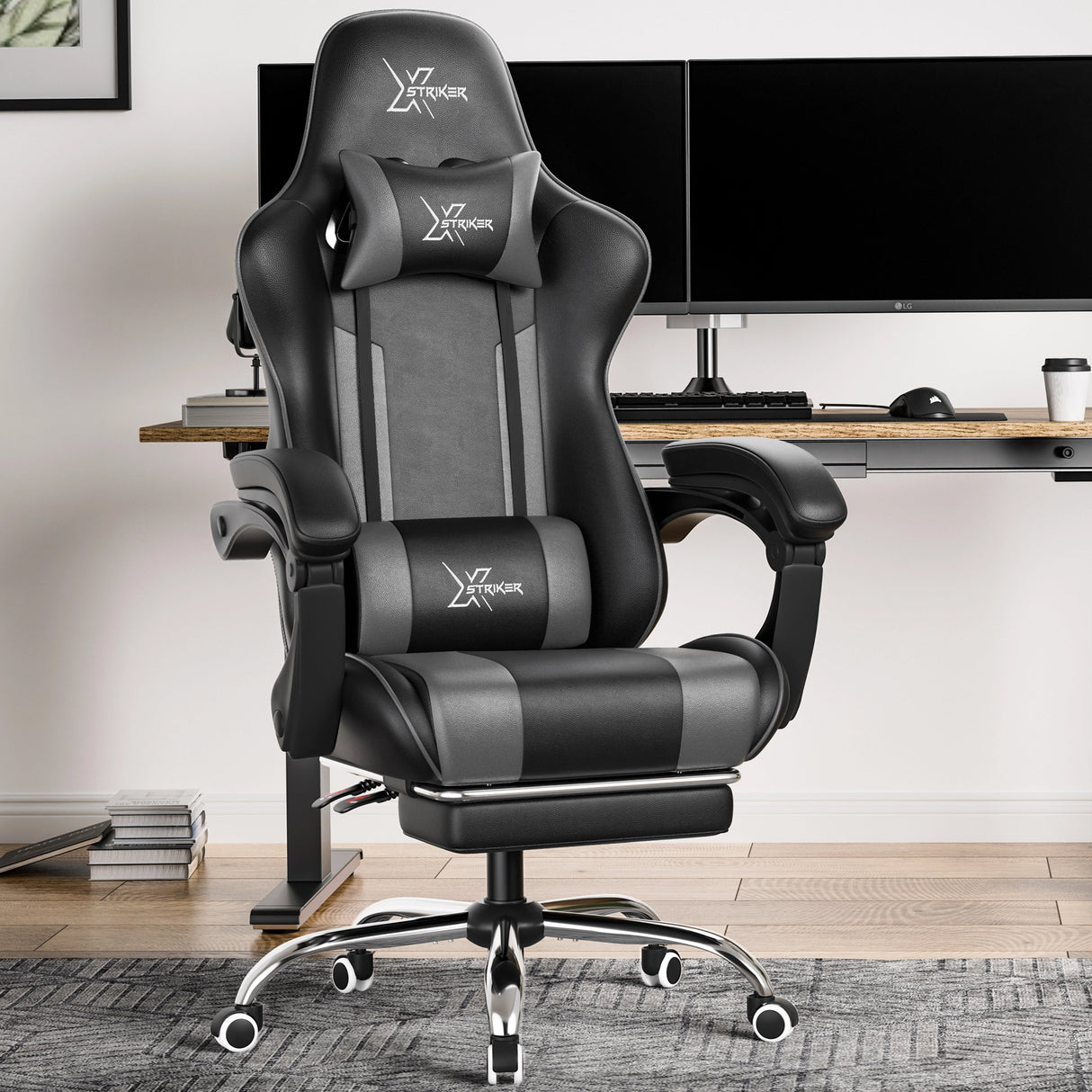 Xstriker Gaming Chair With Footrest in black and grey, featuring ergonomic lumbar support and headrest, placed in a modern home office setup.