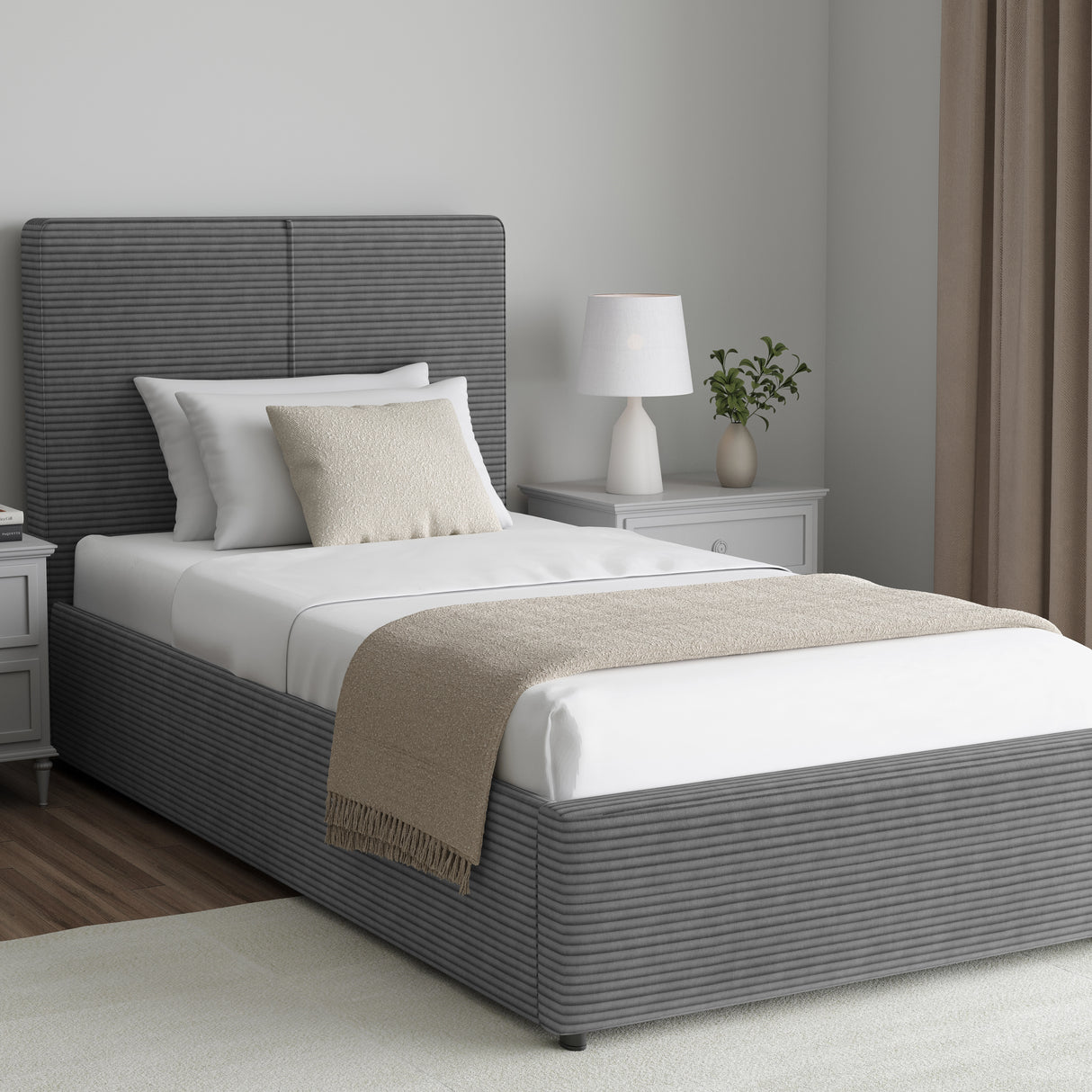 Corduroy ribbed velvet upholstered ottoman bed frame with storage in grey, shown in single size with white bedding in a modern bedroom.