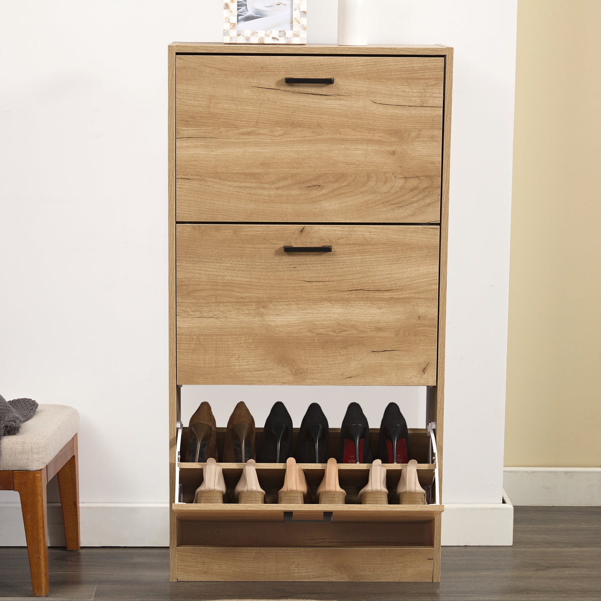 Shoe cabinet hallway view with the bottom drawer open, showcasing six pairs of shoes neatly in place.