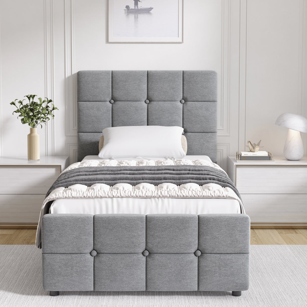 Gray upholstered bed in a bedroom setting with white walls and decor.