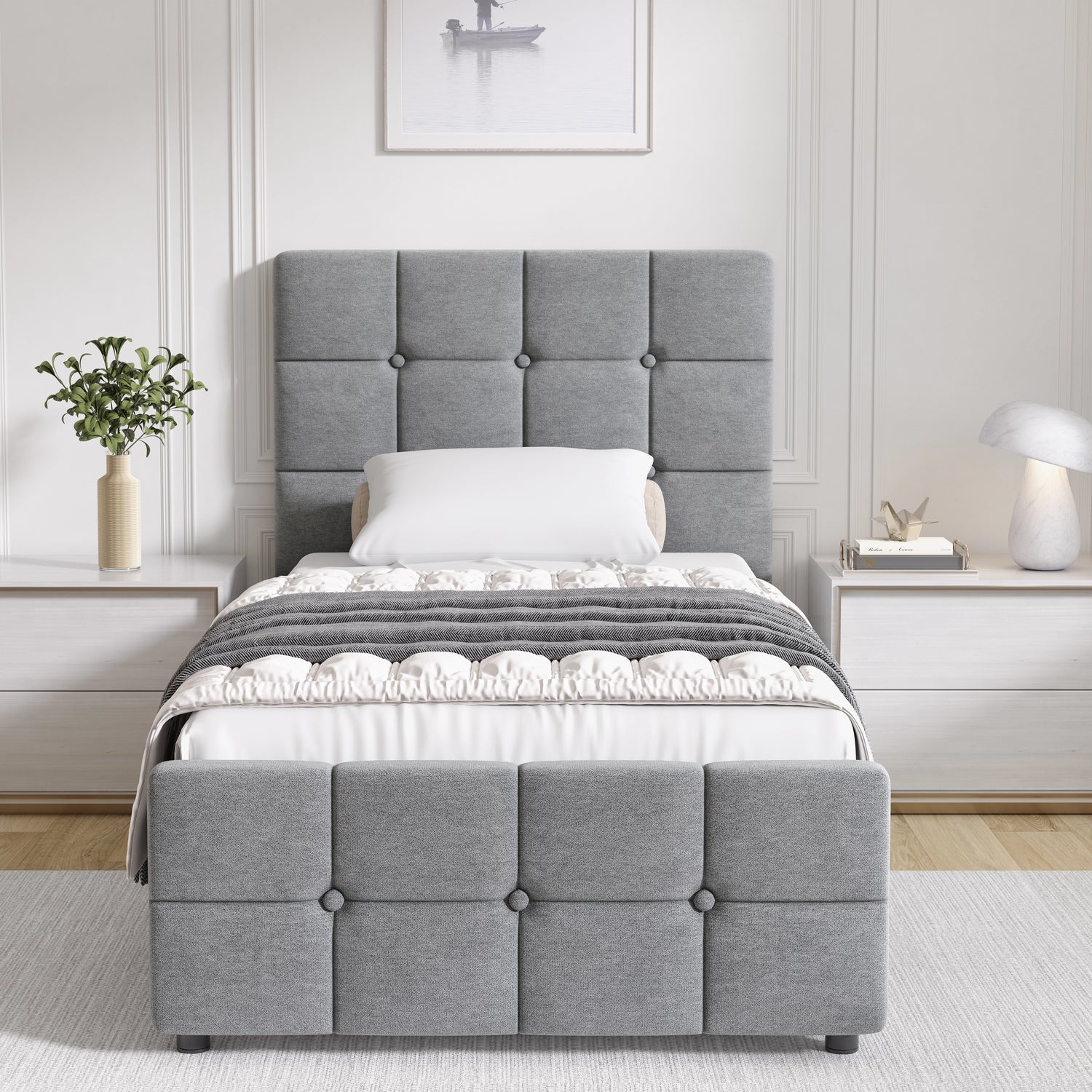 Gray upholstered bed in a bedroom setting with white walls and decor.