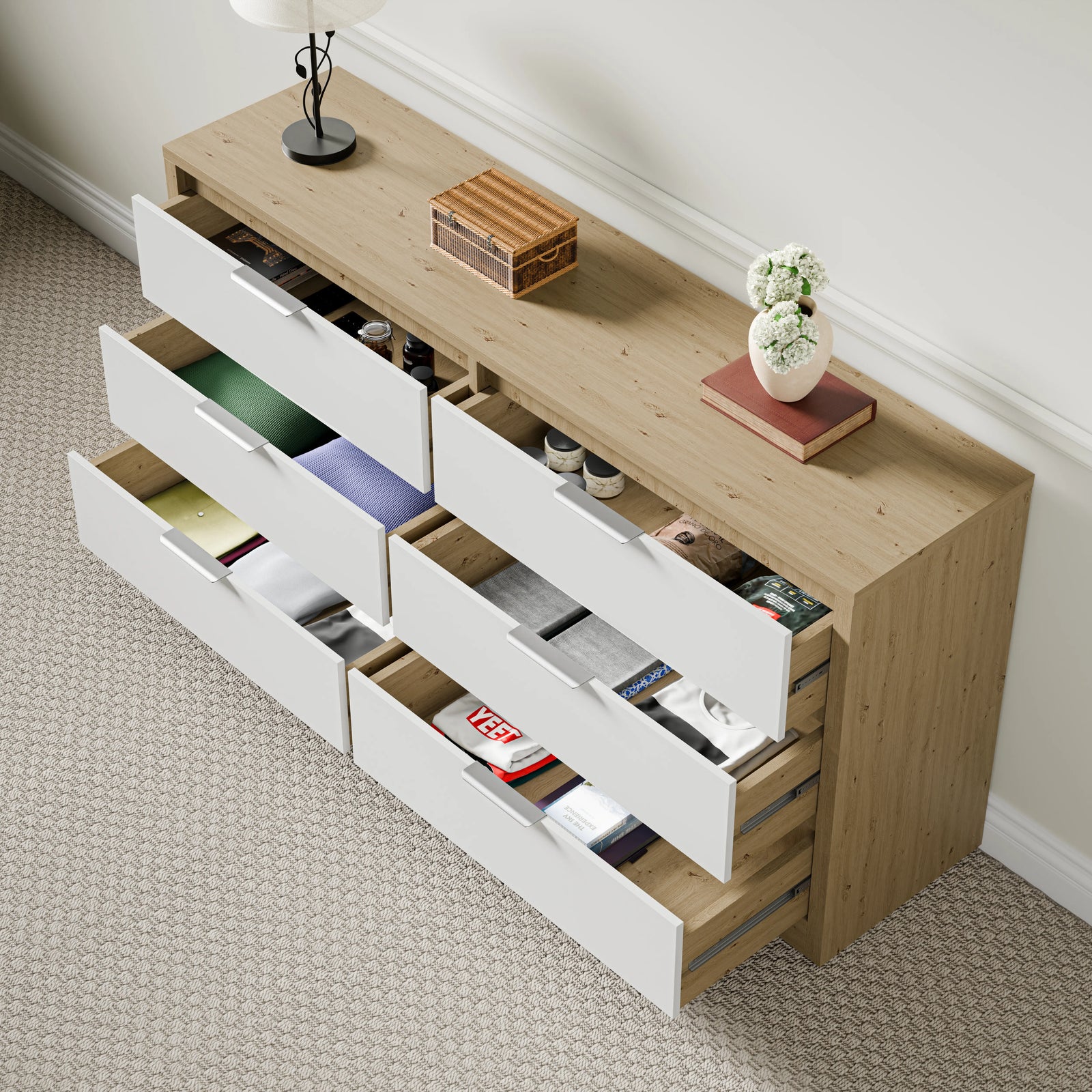 Partially open bedroom drawers in oak and white finish with decorative items on top, placed against the wall