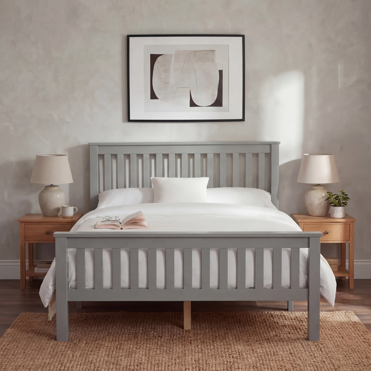 Grey wooden double bed frame with vertical slatted rails, with layered bedding, and placed in a natural light bedroom