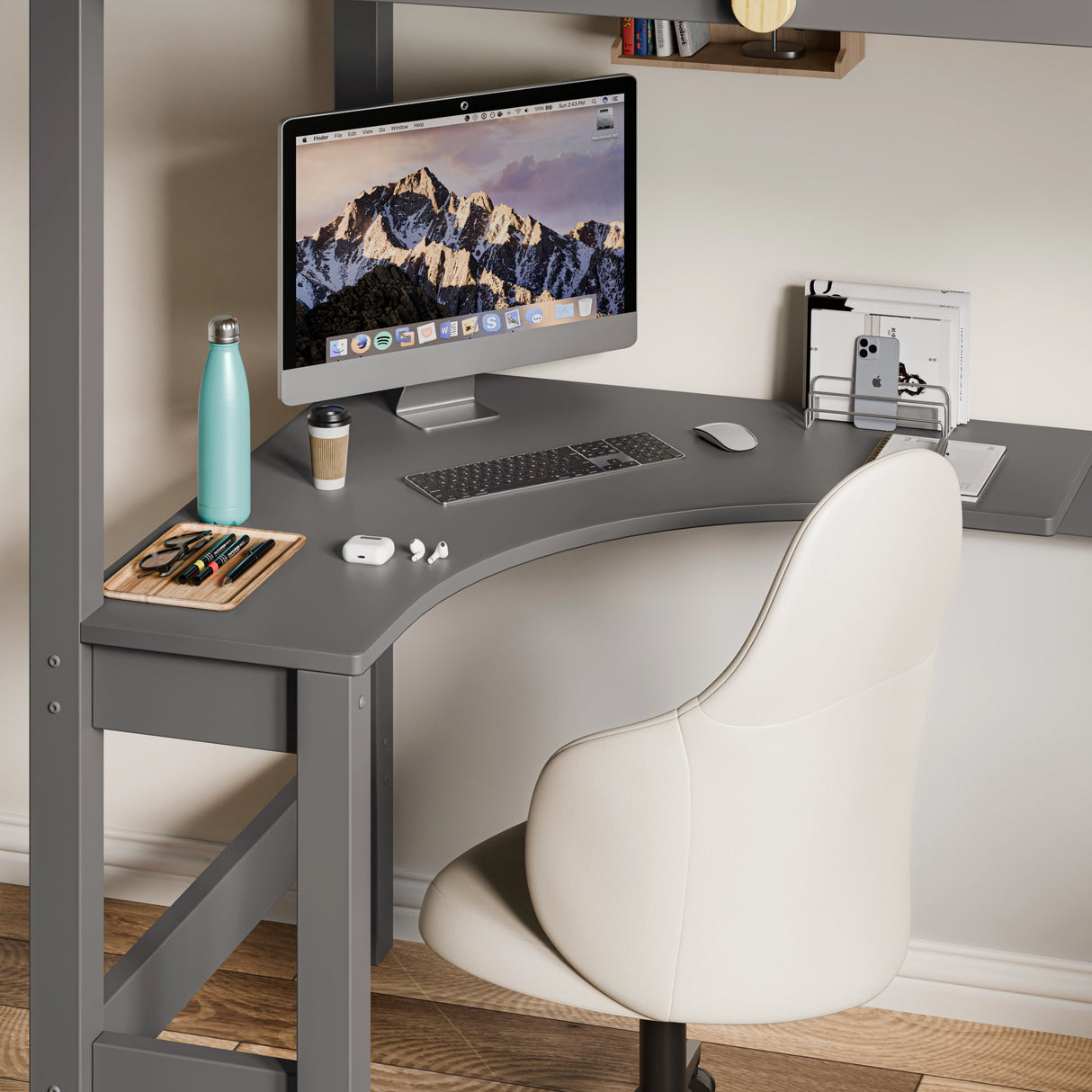 Space-saving corner workstation with neatly organised computer setup and a grey chair under the bunk bed.