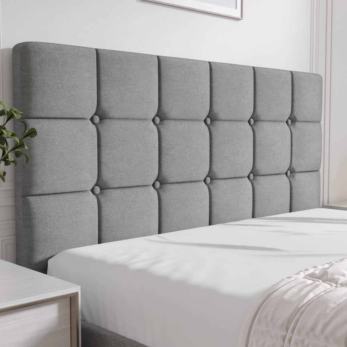 Gray tufted headboard on a bed in a bedroom setting