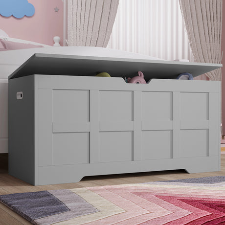 Gray toy storage box with children's toys inside, placed on a wooden floor in a room with pink walls and a colorful rug.